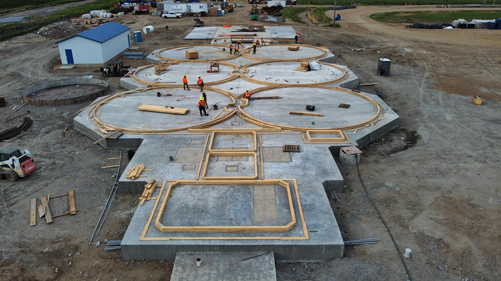 Wide view of entire project with concrete slab floor and wooden forms started for bins
